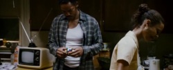 Screencap of Chris holding a Rubik's cube while his wife Linda is doing the dishes.